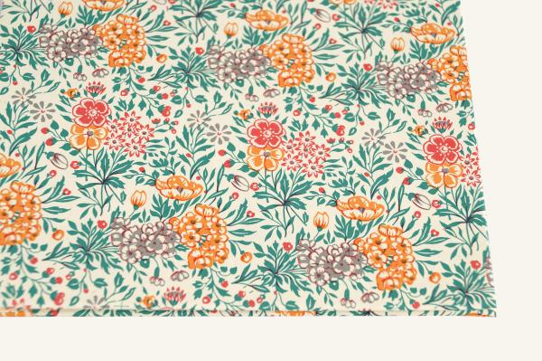 Photo album with a graphic flower pattern in orange and yellow, with a red satin ribbon for tying